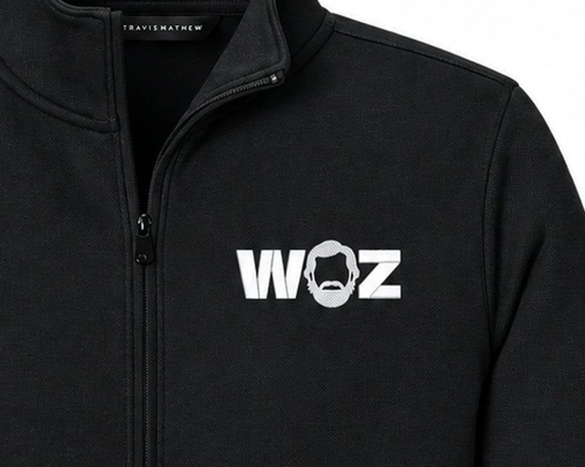 WOZ × TravisMathew Women's Quarter-Zip - chest artwork and quarter zip, cropped from the existing catalog image.
