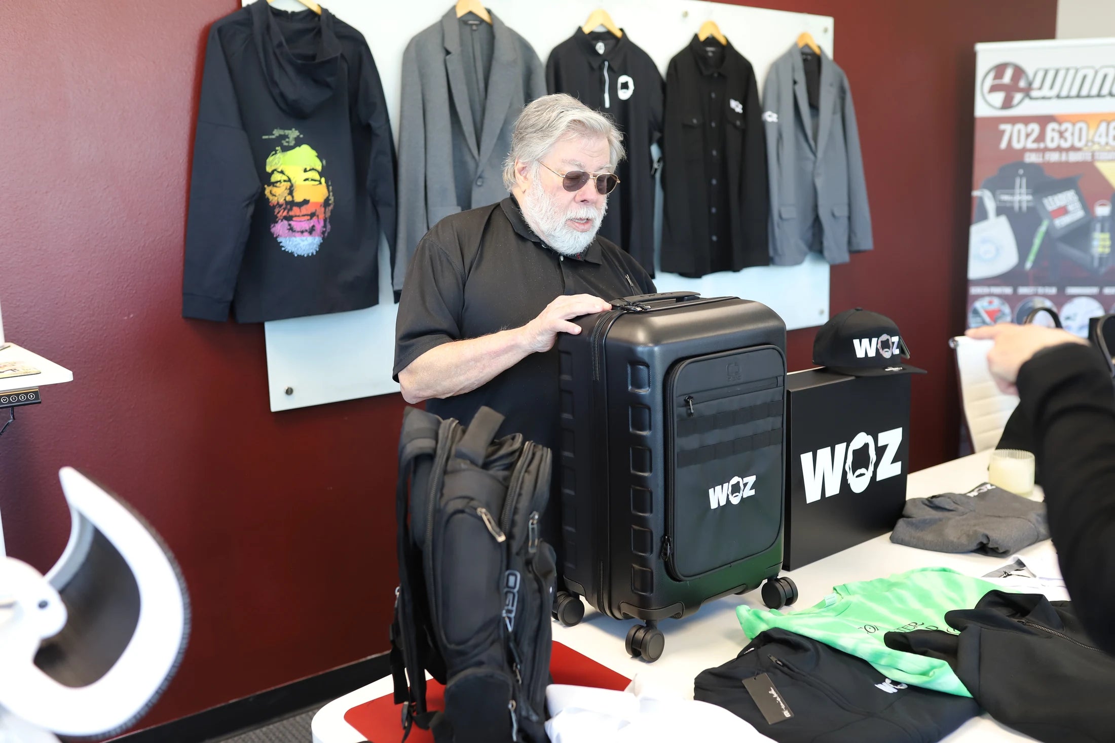 Woz examining WOZ-branded luggage.