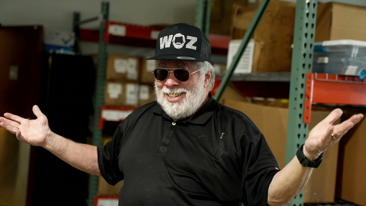 Steve Wozniak smiling while wearing a WOZ cap during his visit to 4Winners Merch.