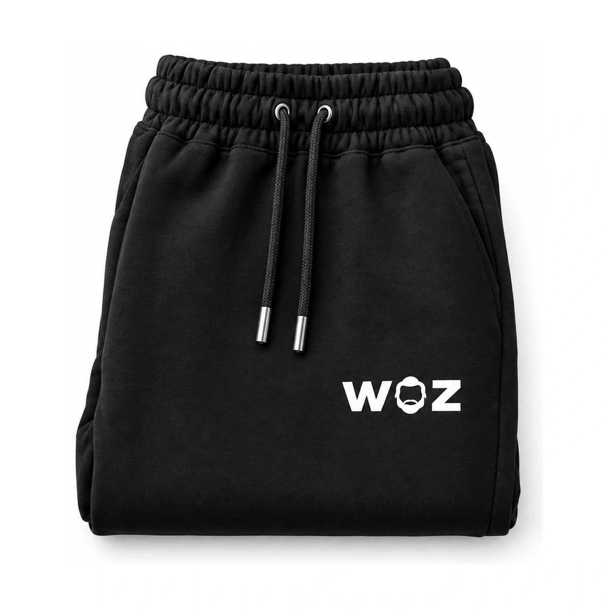 Black WOZ joggers with white drawstrings, folded front view on white. Product render.